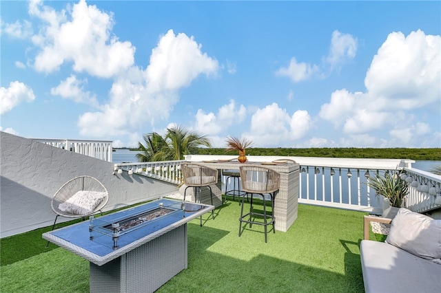 view of patio with a water view and a fire pit