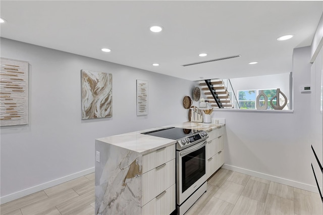 kitchen featuring stainless steel electric range oven, light stone counters, and kitchen peninsula