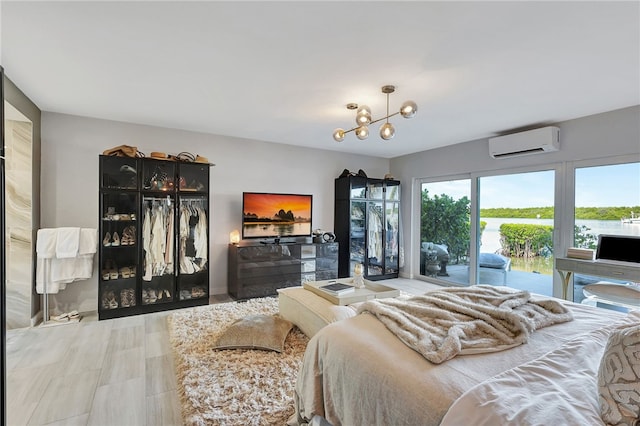 bedroom featuring an inviting chandelier, access to outside, and a wall mounted air conditioner