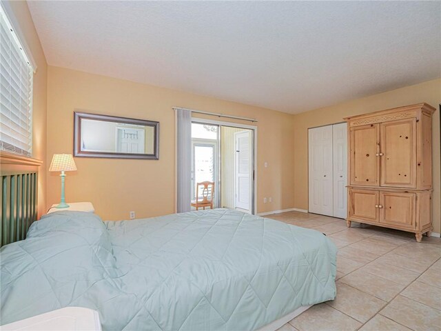 bedroom with a closet, baseboards, and light tile patterned flooring