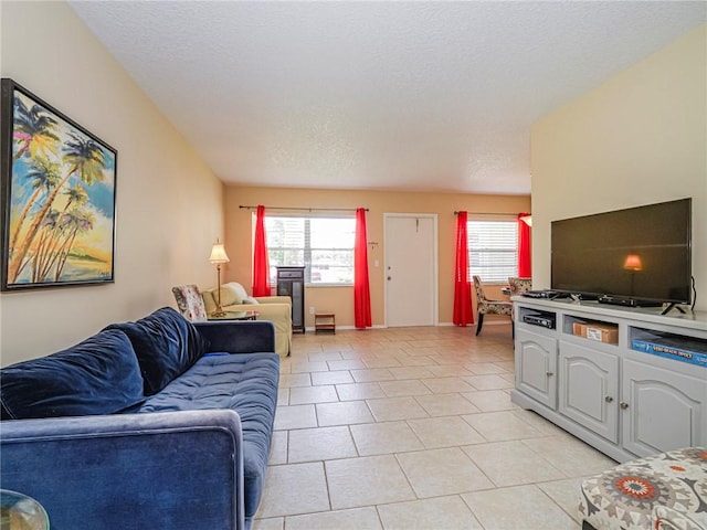 living area with a wealth of natural light, light tile patterned flooring, and a textured ceiling