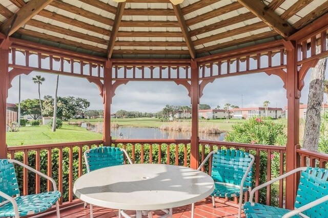 wooden deck featuring a water view, a gazebo, a yard, and outdoor dining area