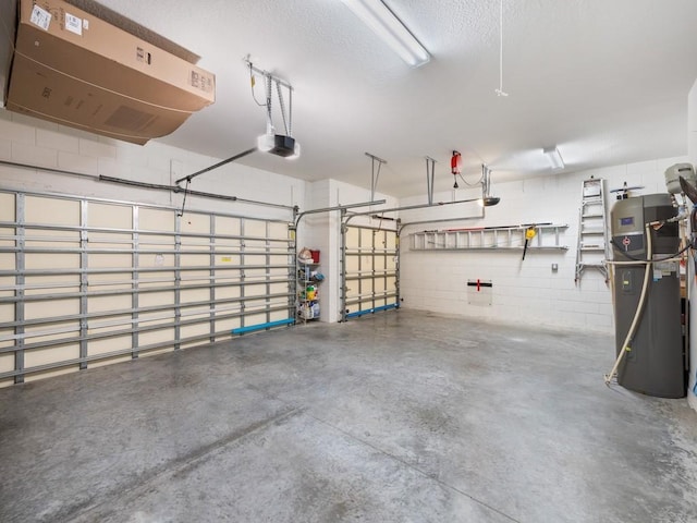 garage featuring water heater, concrete block wall, and a garage door opener