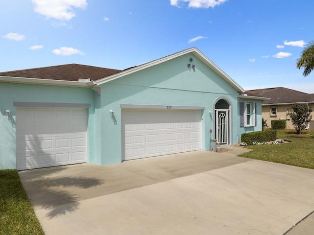 single story home with a garage, roof with shingles, driveway, and stucco siding