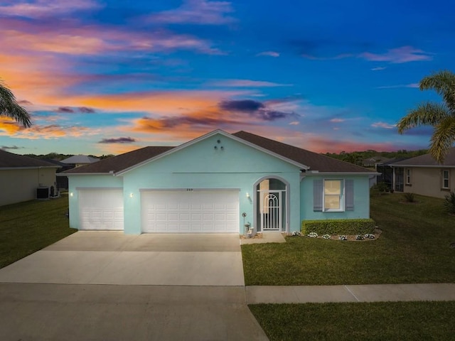 ranch-style house featuring cooling unit, stucco siding, a lawn, a garage, and concrete driveway