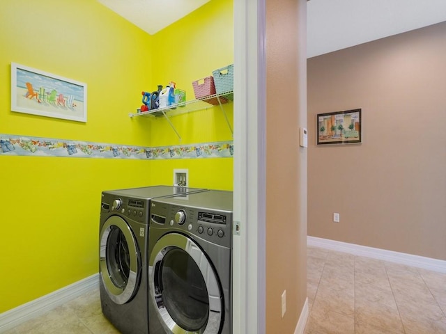 laundry room with independent washer and dryer, light tile patterned flooring, laundry area, and baseboards