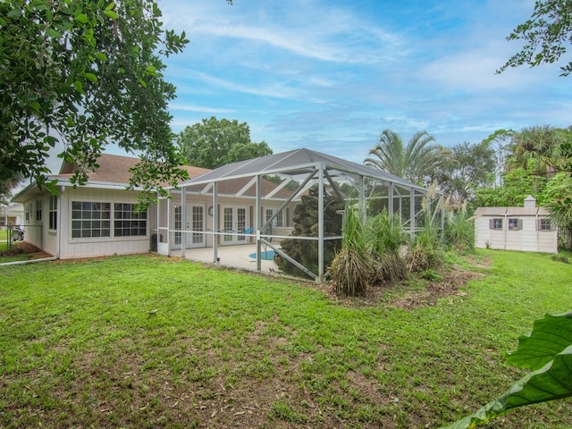 back of property with glass enclosure, a yard, and a shed