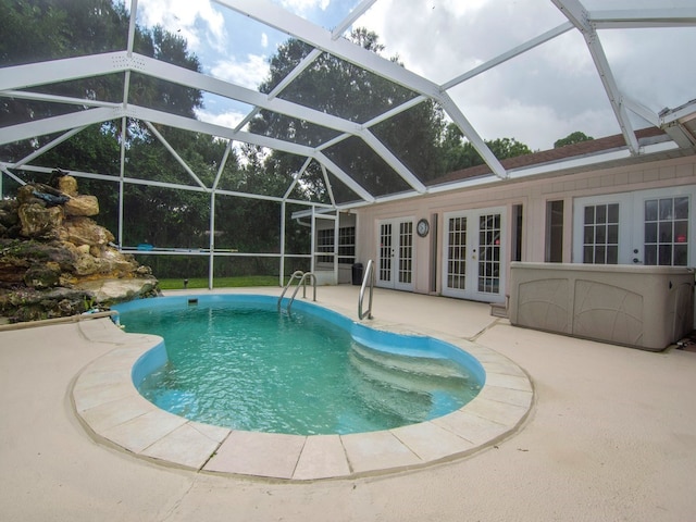 view of pool featuring glass enclosure, a patio area, and french doors