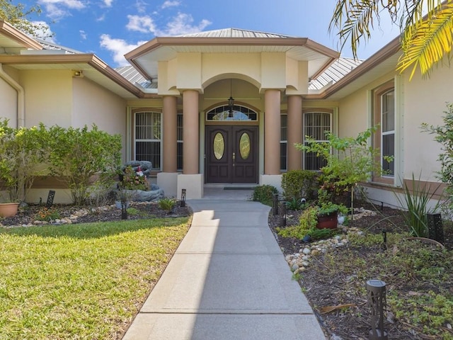 doorway to property with stucco siding and a lawn