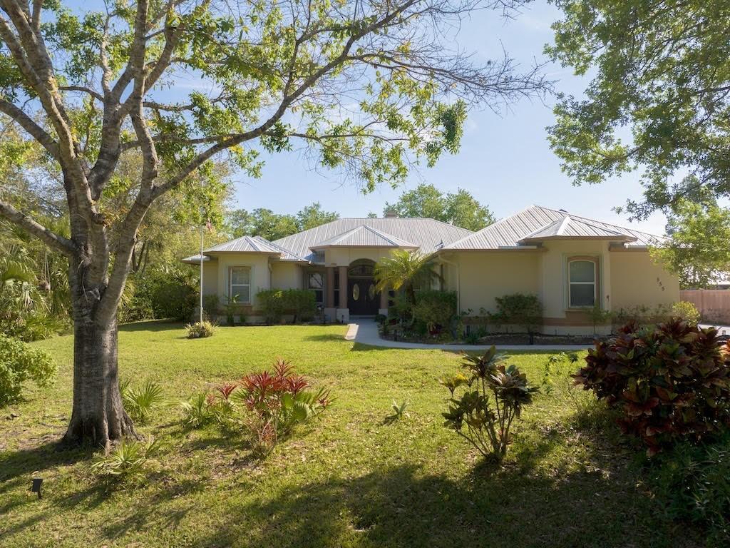 ranch-style house featuring stucco siding, metal roof, and a front lawn