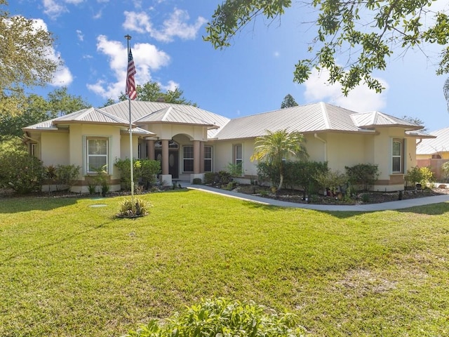 view of front of house featuring stucco siding, metal roof, and a front yard