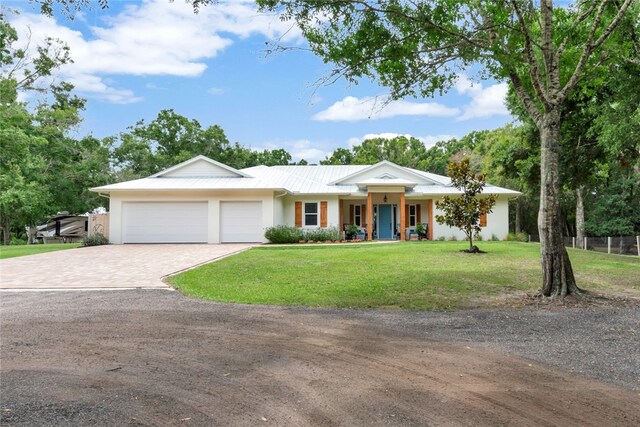 single story home featuring a garage and a front yard