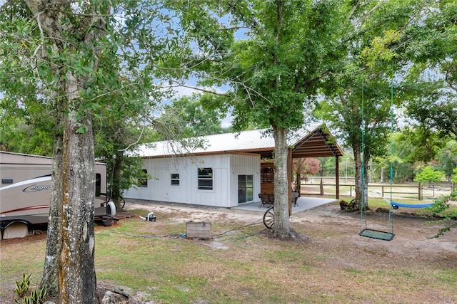 rear view of property featuring a lawn and a patio area