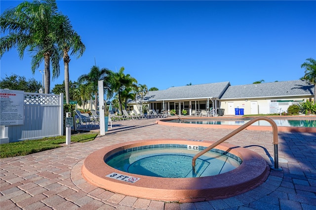 view of pool with a hot tub and a patio