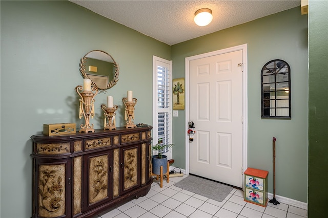 foyer with a textured ceiling and light tile patterned flooring