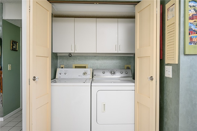 laundry area featuring cabinets, washer and dryer, and light tile patterned floors