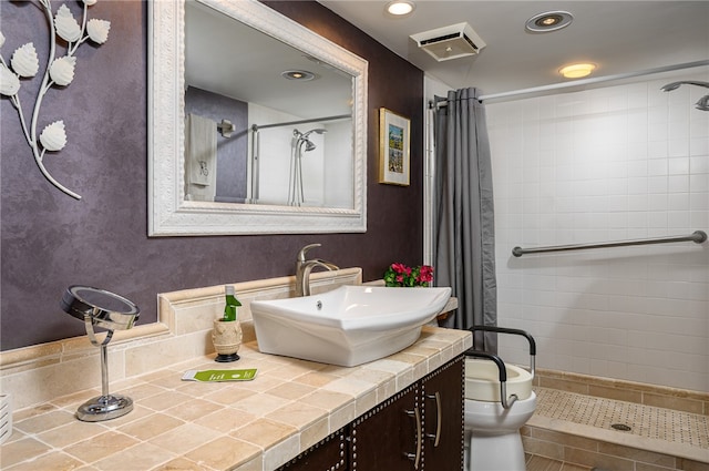 bathroom featuring toilet, vanity, tile patterned floors, and curtained shower