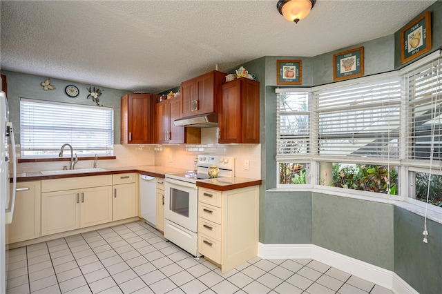 kitchen featuring white appliances, a textured ceiling, sink, and light tile patterned flooring