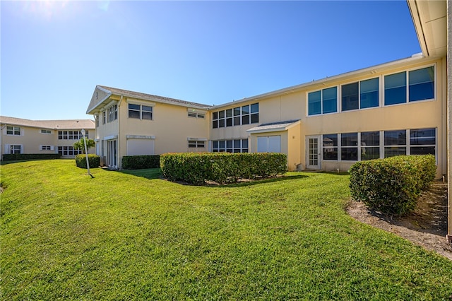 rear view of property with a lawn