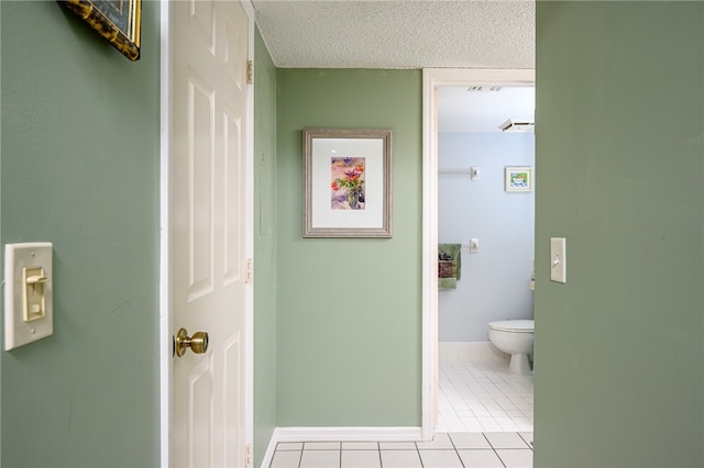 bathroom with tile patterned floors, toilet, and a textured ceiling