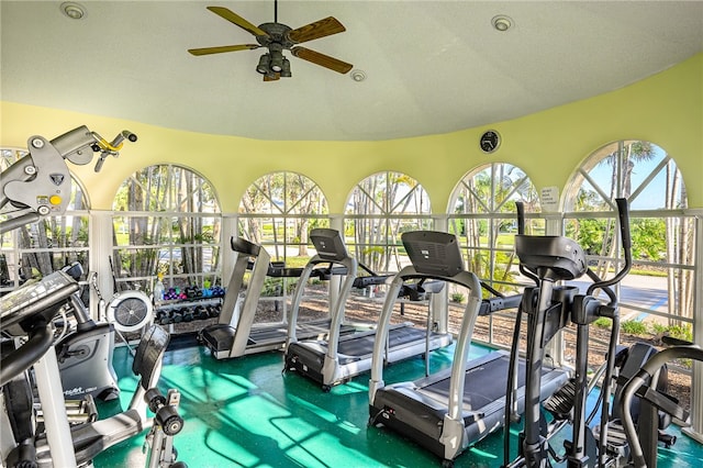 workout area featuring ceiling fan, a textured ceiling, and lofted ceiling