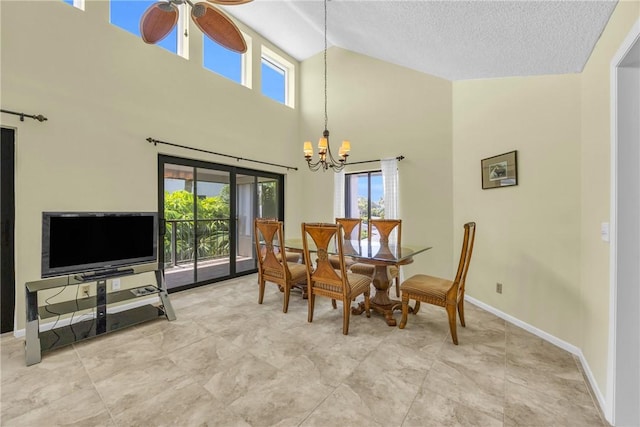dining area featuring ceiling fan with notable chandelier, high vaulted ceiling, baseboards, and a healthy amount of sunlight