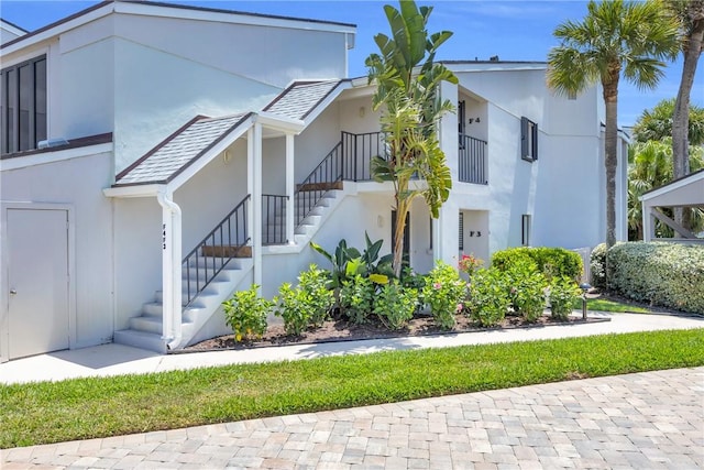 view of front of house featuring stucco siding and stairs
