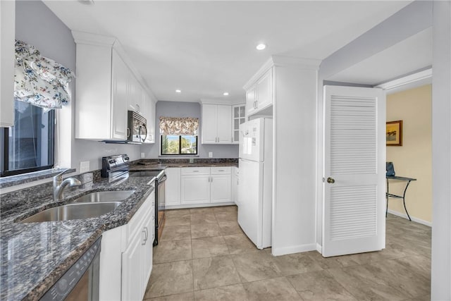 kitchen featuring recessed lighting, a sink, white cabinets, and stainless steel appliances
