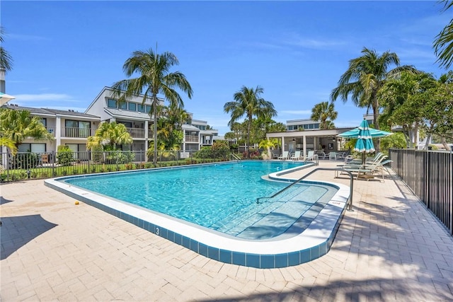 community pool featuring fence and a patio