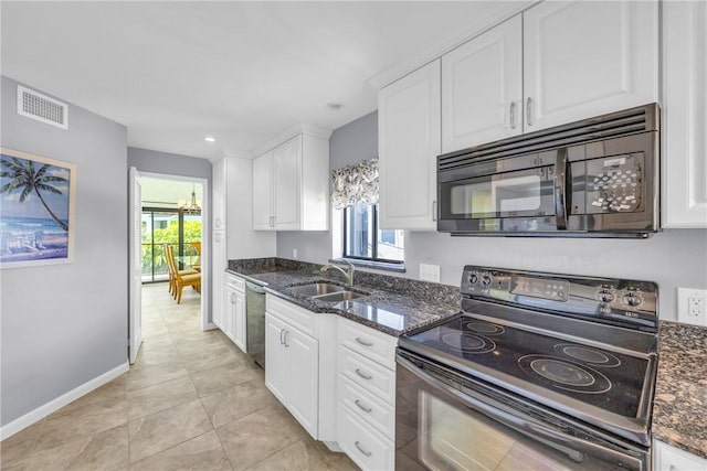 kitchen featuring plenty of natural light, white cabinets, black appliances, a sink, and visible vents