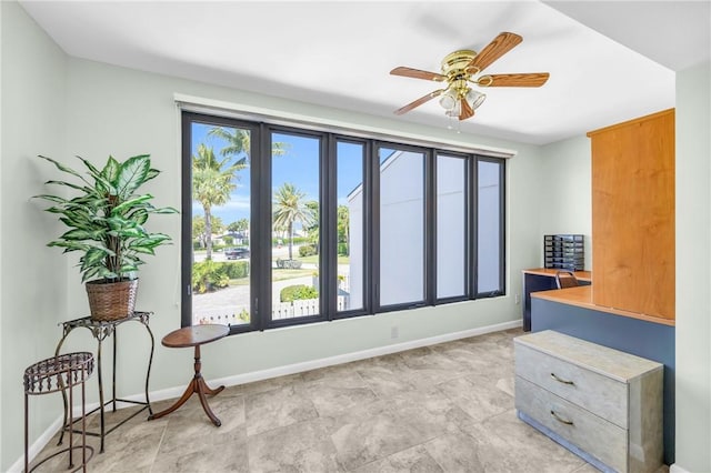 interior space featuring ceiling fan and baseboards
