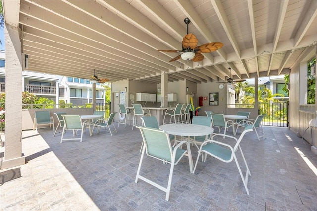 view of patio / terrace featuring a ceiling fan, outdoor dining space, and fence