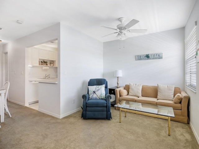 living area with light carpet, ceiling fan, and baseboards