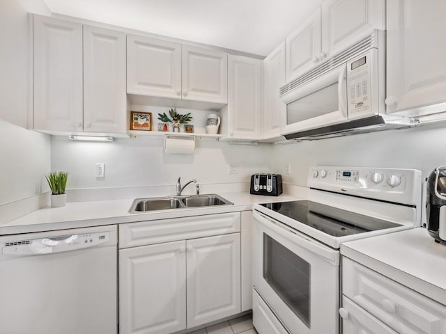 kitchen featuring white appliances, a sink, white cabinetry, light countertops, and open shelves