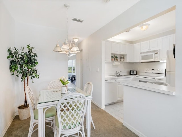 dining space with baseboards, light colored carpet, visible vents, and an inviting chandelier