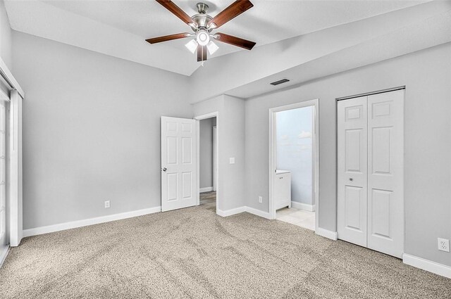 1545 22nd Ave SW, Vero Beach, FL 32962 - unfurnished bedroom featuring carpet floors, vaulted ceiling, multiple windows, ensuite bath, and ceiling fan