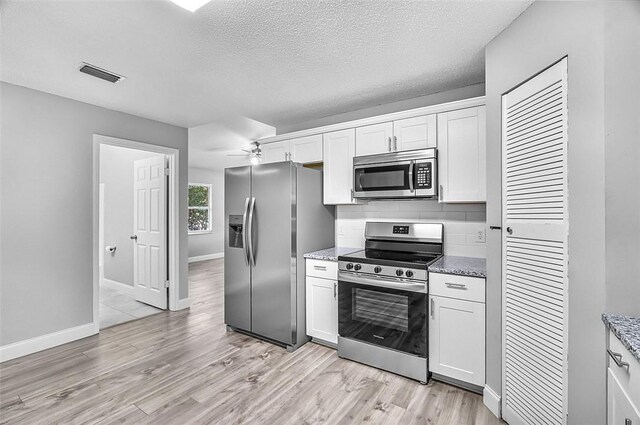 1545 22nd Ave SW, Vero Beach, FL 32962 - kitchen featuring stainless steel appliances, light wood-type flooring, white cabinetry, decorative backsplash, and a textured ceiling