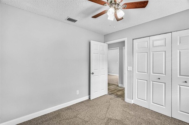 1545 22nd Ave SW, Vero Beach, FL 32962 - unfurnished bedroom with a textured ceiling, carpet flooring, a closet, and a ceiling fan