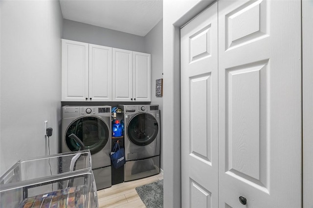 laundry room with cabinets, independent washer and dryer, and light wood-type flooring