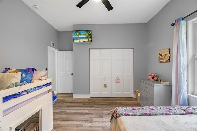 bedroom with hardwood / wood-style floors, ceiling fan, and a closet