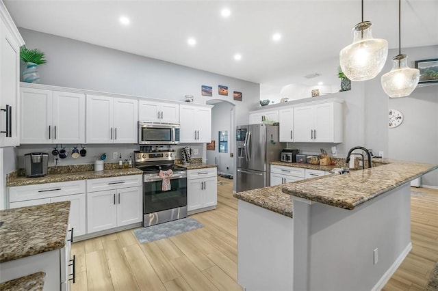kitchen featuring sink, light hardwood / wood-style flooring, white cabinetry, hanging light fixtures, and stainless steel appliances