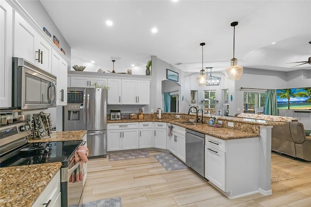 kitchen featuring white cabinetry, appliances with stainless steel finishes, sink, and decorative light fixtures