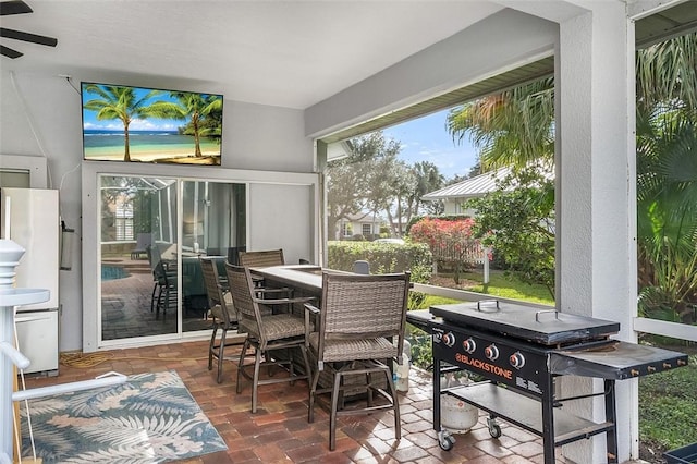 sunroom / solarium featuring ceiling fan