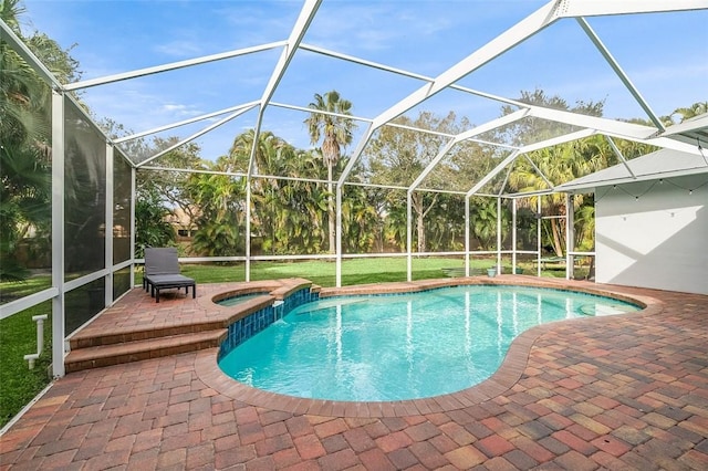 view of pool featuring an in ground hot tub, a patio area, and glass enclosure