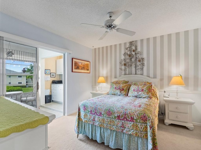 bedroom featuring light carpet, a textured ceiling, ensuite bath, and ceiling fan