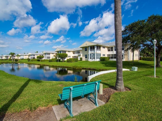 view of property's community featuring a yard and a water view