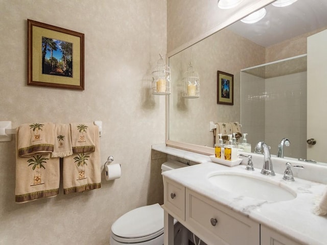 bathroom with vanity, toilet, and a tile shower