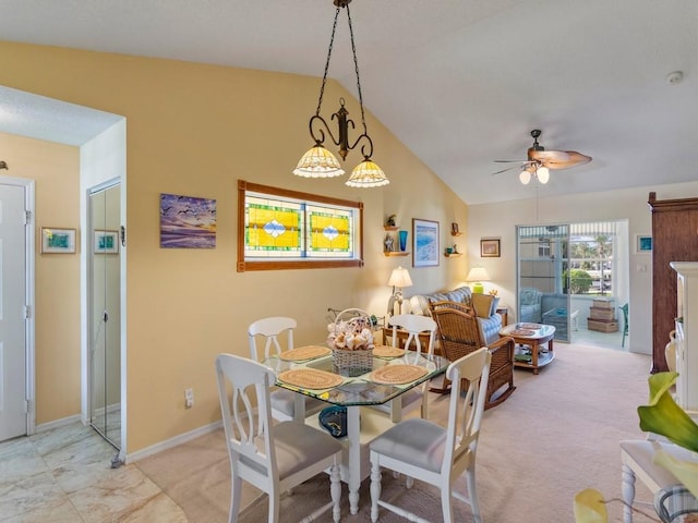 carpeted dining area with ceiling fan and lofted ceiling