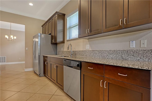 kitchen with stainless steel appliances, a chandelier, crown molding, light stone counters, and sink