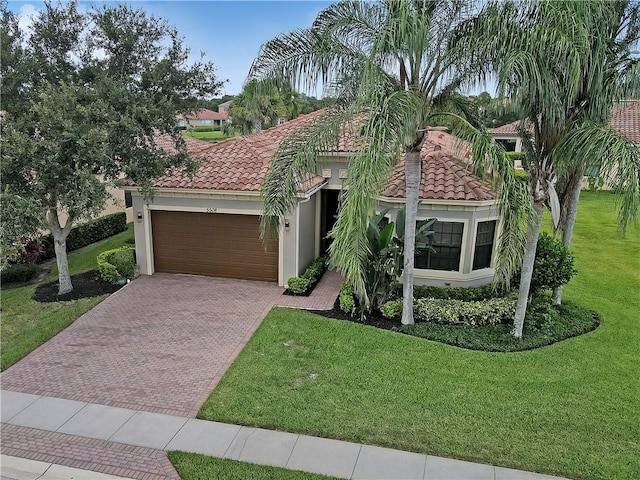 mediterranean / spanish home featuring a front lawn and a garage